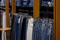 Denim blue jeans on hangers in store on blurred background. Shopping time concept Royalty Free Stock Photo