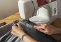 Denim cloth on sewing machine closeup. Seamstress work process concept