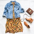 Denim jacket, vintage floral print dress, suede red chelsea boots and leather bag on a light background, top view. Beauty fashion Royalty Free Stock Photo