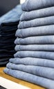 Denim jeans or pants on a shelf in a boutique clothing and apparel store or shop