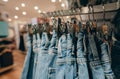 Denim pants in clothing store. Jeans on hanger hanging on rack in clothing store. Fashion retail shop inside shopping mall. Royalty Free Stock Photo