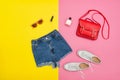 Denim shorts, white sneakers, red handbag, sunglasses. Bright ye Royalty Free Stock Photo