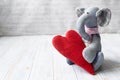 Denim vintage elephant, handmade with a textile red heart, on a light wooden background