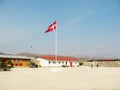 Denmark, flag and building on landscape with blue sky for military training, bootcamp or government land. Army, base and