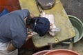 A woman is cutting chicken meat to sell in her stall