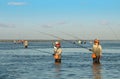 DENPASAR, INDONESIA - May 24 Traditional Balinese fishermen standing in shallow water at low tide on the beach at Nusa Dua, Denpas Royalty Free Stock Photo