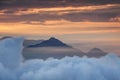 Dense cloud layer with conical peak and orange morning mist Royalty Free Stock Photo