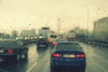 Dense traffic on a rainy day. Traffic in rainy day with road view through car window with rain drops. Blurry image, Rain Royalty Free Stock Photo