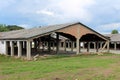 Densely built wide hangar buildings with destroyed support walls and unusual bent roofs at abandoned military complex