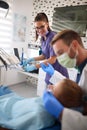 Dental assistant and dentist working with patient