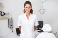 Dental assistant smiling at camera beside chair Royalty Free Stock Photo