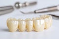 Ceramic Dental Bridge and Dental Instruments on White Background Royalty Free Stock Photo