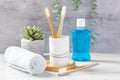 Dental health care concept, bamboo toothbrushes in cup with mouthwash and towel