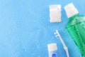 Dental care and oral hygiene concept with a bottle of green mouthwash, toothbrush, dental floss and tube of toothpaste soaked in Royalty Free Stock Photo