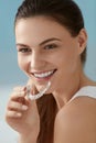 Dental care. Smiling woman using removable clear teeth braces