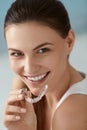 Dental care. Smiling woman using removable clear teeth braces