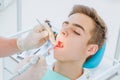 Dental caries prevention.Teenage boy at the dentist`s chair during a dental procedure, smile close up. Healthy Smile Royalty Free Stock Photo