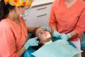 Dental checkup, being given to young girl, by female dentist with assistant Royalty Free Stock Photo