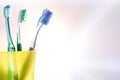 Daily dental cleaning with yellow plastic cup with toothbrushes detail Royalty Free Stock Photo