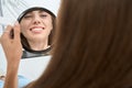 Dental clinic client admiring her clean white teeth