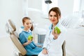 Dental Clinic. Female Dentist And Little Patient Eating Apple