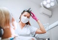 Dental clinic patient appointment in modern medical ward. Dentist doctor in magnifying glasses smiling with eyes young Female