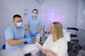 dental clinic patient reception in lilac hall with stars intimate atmosphere doctor and nurse in masks wearing blue