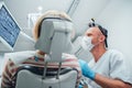 Dental clinic patient visit in modern medical ward. Dentist doctor in magnifying glasses evaluating Dental X-rays scan. Patient