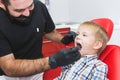 Dental clinic. Reception, examination of the patient. Teeth care. Dentist treating teeth of little boy in dentist office Royalty Free Stock Photo