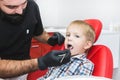 Dental clinic. Reception, examination of the patient. Teeth care. Dentist treating teeth of little boy in dentist office Royalty Free Stock Photo