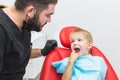 Dental clinic. Reception, examination of the patient. Teeth care. Dentist treating teeth of little boy in dentist office Royalty Free Stock Photo