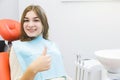 Dental clinic. Reception, examination of the patient. Teeth care. Young girl shows thumb up sign in dentist office Royalty Free Stock Photo