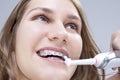 Dental Concept and Ideas. Extreme Closeup Portrait of Caucasian Teenage Girl Brushing Teeth Brackets with Electric Toothbrush