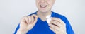 Dental floss close up. A man in front of a mirror brushes his teeth with flossing. The concept of proper oral care. Selective Royalty Free Stock Photo