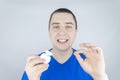 Dental floss close up. A man in front of a mirror brushes his teeth with flossing. The concept of proper oral care. Selective Royalty Free Stock Photo