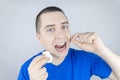 Dental floss close up. A man in front of a mirror brushes his teeth with flossing. The concept of proper oral care. Selective Royalty Free Stock Photo