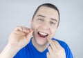 Dental floss close up. A man in front of a mirror brushes his teeth with flossing. The concept of proper oral care. Selective Royalty Free Stock Photo