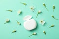 Dental floss and flowers on mint background