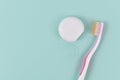 Dental floss and tooth brush on side of green background Royalty Free Stock Photo