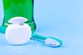 Dental floss, toothbrush and mouthwash on blue background. Tooth care and oral hygiene products Royalty Free Stock Photo