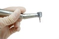 Dental handpiece in the hands of the dentist isolated on white background close-up, dental drill