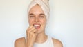 Dental health care. Beautiful young woman with towel on her hair cleaning teeth with dental floss isolated over white background Royalty Free Stock Photo