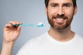 Dental health concept. Handsome middle aged man holding toothbrush and smiling, ready for brushing his teeth Royalty Free Stock Photo