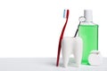 Dental health and teethcare concept. Dental mirror in white tooth model near mouthwash, toothbrush and dental floss against white Royalty Free Stock Photo