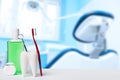 Dental health and teethcare concept. Dental mirror in white tooth model near mouthwash, toothbrush and dental floss against dental Royalty Free Stock Photo