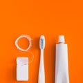 Dental hygiene objects: toothbrush, toothpaste and floss.