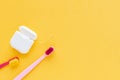 Dental hygiene - tooth brushes, dental floss flat lay, top view, copy space, yellow background