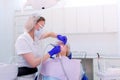 Dental hygienist cleaning and brushing woman`s teeth uses drill with brush.