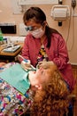 Dental hygienist cleaning patient's teeth