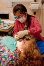 Dental hygienist cleaning patient's teeth